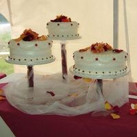 Emmy's Wedding Cake 8,10,12" cakes; 10" chocolate, other two white with raspberry filling; almond buttercream frosting; fondant rolled roses at top...