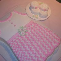 Baby Dress With Booties 11 X 15 Sheet cut into shape of dress. Booties are made from 1 and 1/2 cup cakes. Decorations are buttercream, edible pearls, and royal...