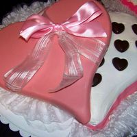 Box Of Chocolates Heart-shaped cake with buttercream icing. Chocolate candies for candy pieces and lid is made from molded chocolate.