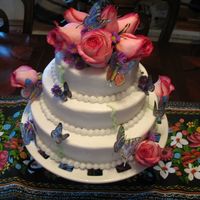 Kim's Butterflies 6", 8", 10" single layers stacked with white buttercream and edible wafer paper butterflies and fresh roses.
