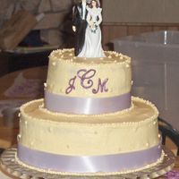 Violet And Ivory 10inch round with 6 inch round on top basic white cake with basic bc icing. ribbon around the bottom and chocolate for the monogram.