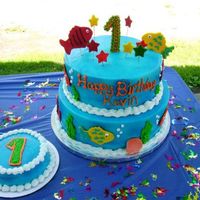 Fishy 1St Birthday Cake 12" & 10" neopolitan cake, buttercream filling and icing, gumpaste 1, fish and stars on top and MMF fish and shells around...