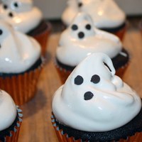 Ghost Cupcakes swiss meringue ghost cupcakes. i should have made icing alittle sturdier becuase the ghost kindof deflated. eyes and mouth are chocolate...