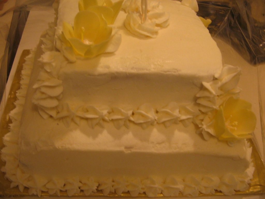 Img_0486.jpg this is a 2 tier french vanilla cake with BC frosting. the yellow tulips made with fondant and royal icing for the inside parts of the...
