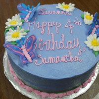 Butterfly Fantasy Royal Icing butterflies and Daisies adorn this 9" lavender buttercream layer cake.