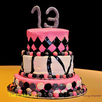Pink Black And Grey A three tiered cake for a 13th birthday. It is a buttercream base with fondant accents.