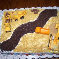 Construction Cake This was done for a one year olds birthday. Everything is edilble except the toy tractors and trucks. This was a yellow butter cake with bc...