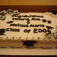 Black & White Double Graduation White cake, buttercream icing, & chocolate filling. The flowers, grad caps, grad silhouttes, & diploma are made from fondant