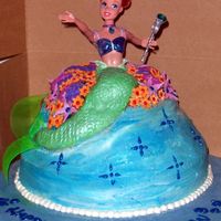 Mermaid.jpg For a 4 year old's birthday. Scratch chocolate cake with chocolate ganache filling & buttercream icing. MMF tail and flowers.