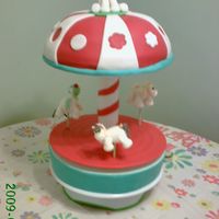 Carousel Horse Carousel with horses that spin. Three horses that are in differents levels and one sitting on the top. The cake is the top part.