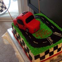Race Car Track Birthday Cake This is a 2 layer, 11X15 vanilla chocolate chip and chocolate chocolate chip with raspberry mousse filling. Car is all fondant. I don'...