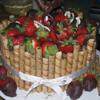 Larrys_Bday.jpg german chocolate cake and frosting with strawberries and pirouttes