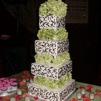 Kiley's Wedding Cake 4 tiered cake iced in bc, decorated with brown scrolls and green hydrangeas between each tier. Cake design is based off of a picture of a...
