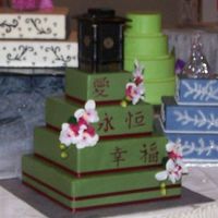 Oriental Themed Wedding Cake This is another dummy cake. covered in fondant silk orchids and ribbon onthe borders of cake. words painted by hand from a very good friend...
