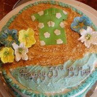 Luau Buttercream, with royal icing flowers, and fondant for the shirt. Crushed graham crackers as the "sand".