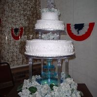Dscf0015.jpg My first wedding cake. Luckily it was a freebie for a friend's son. I put the 2 smal tiers together at home and they shifted a little...