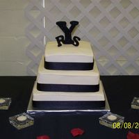 Simple Wedding Cake Vanilla cake with ivory buttercream frosting. Black ribbon around each tier. The bride made the initials for the cake.
