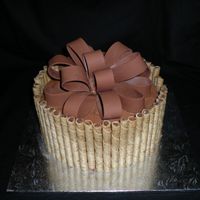 Erics Bday 8" Choc cake with choc mousse filling. Iced in Choc buttercream with piroutte cookies. Bow made of fondant. This was for a man's...