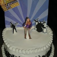 Hannah Montana 8" iced in B/C. Backdrop is made of chocolate. Hannah, band mates and crowd are an edible image backed with chocolate. TFL!
