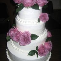 Wedding Cake With Purple Roses I had to bake and assemble this cake during 95 degree weather and 90% humidity! And then the wedding was outdoors...next to the ocean!...