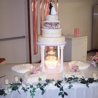 White Wedding Vanilla cake covered in candy clay with edible rhinestone sccents. Flowers are real roses. Two of the hearts accent cakes are sugar free...