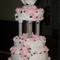 Pink Roses Royal icing pink roses adorn a buttercream cake with silver pillars and dragees.