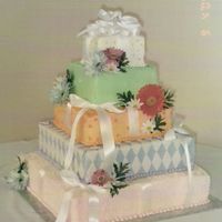 Present Cake This cake is buttercream except for the fondant diamonds on the purple cake. The flowers are silk.