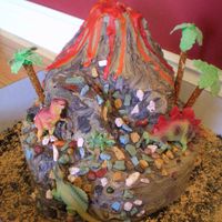 118939275564903.jpg loved making this cake....didn't photograph as well though.....the rocks were candy made of chocolate with a hard shell....dinos were...