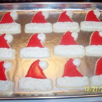 Santa Hat Cookies White Velvet Sugar Cookies with poured icing and buttercream icings. Hat trim sprinkled with edible glitter.