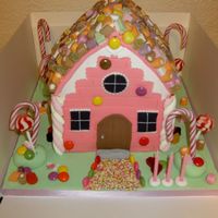 Candy House 8" and 6" square cakes carved into shape of house, covered with sugarpaste and decorated with sweets.