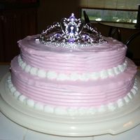 Princess Cake Two tiered pink princess cake. Topped with a tiara. Buttercream icing.