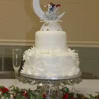 White On White Wedding Simple 6, 10 inch wedding cake, top tier white, bottom chocolate. White buttercream with fondant flowers. I wish I had taken a picture...