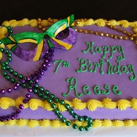 Mardi Gras Birthday Cake 9x13 yellow butter cake with buttercream frosting. Mask is gumpaste, hand painted with Americolor food color mixed with vodka and gold...