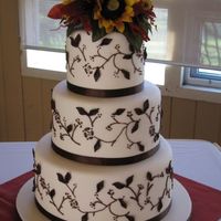 Fall Flowers Ivory fondant with chocolate buttercream piping and chocolate fondant leaves. Silk flower topper made by bride.