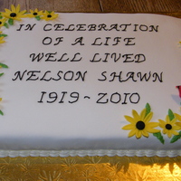 Memorial Lemon cake with cream cheese icing under lemon marshmallow fondant. Fondant flowers and bird.
