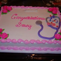 Nurse Graduation White cake with buttercream frosting and flowers. Needle, pills, band-aid and stethoscope are made of mmf.