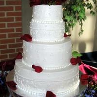 Romance In White Romantic buttercream scrolls, swiss dots and fleur de lis adorn this 4 tiered cake.