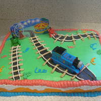 Thomas The Train Cake All buttercream except for the trains and the picture card in the back. Made for alittle boys 4th birthday. Thanks for looking!