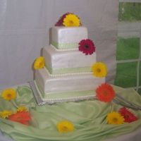 Carrie's Wedding WASC cakes with buttercream filling and fondant . Covered fondant with pearl luster dust and green satin/sheer ribbons and fresh gerber...