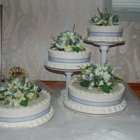 50Th Anniversary 14", 12", 10", and 8" torted rounds. Frosted with buttercream and decorated with ribbon and silk flowers.
