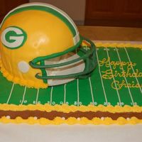 Green Bay Packers Cake a sheet cake decorated with buttercream. The helmet is made using an 8"x3" round on the bottom layer and the domed cake pan rom...