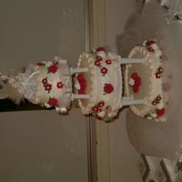 Wedding Cake A 6, 10 & 14" Wedding cake frosted in buttercream with royal roses and fondant bows painted with pearl dust.