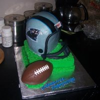 Carolina Panthers Helmet Made with, 2 six inchs rounds, 1 half sports ball pan, sitting on an 8X2 square cake...iced in butter cream, with fondant details. Football...