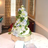 Cascading Roses And Hydrangeas Cake Continued. Side view of cascading roses and hydrangeas wedding cake. Showcasing the side of the cake with the flowers cascading down.