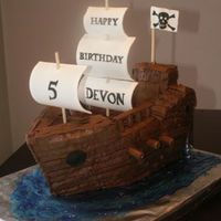 Pirate Ship Chocolate cake filled with chocolate ganache and iced in chocolate buttercream. Sails are gumpaste, and Tootsie Rolls were used for the...