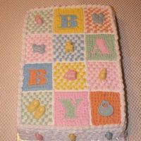 Baby Blanket This baby shower cake is 2 layers of vanilla cake filled with chocolate custard and iced with buttercream. Decorations are made of molded...