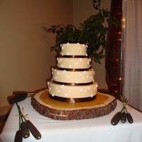 Wedding Cake 4 tier cream coloured wedding cake with brown ribbon and gumpaste flowers