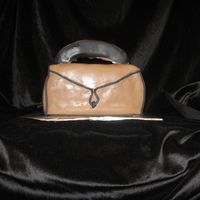 Purse Cake Yellow almond cream cheese pound cake covered in fondant. Handle is cake covered in fondant as well. Donated to a church cake walk.