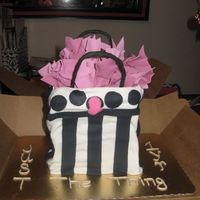 Gift Bag Chocolate cake covered with fondant. Tissue is gumpaste. Gave to a llady celebrating her shops one year anniversary and a breast...