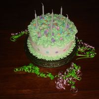 Green Swirls And Rainbow Dots This is a traditional 8" round cake. Green swirls on top and around the base....with Wilton dots pressed into the side and sprinkled...